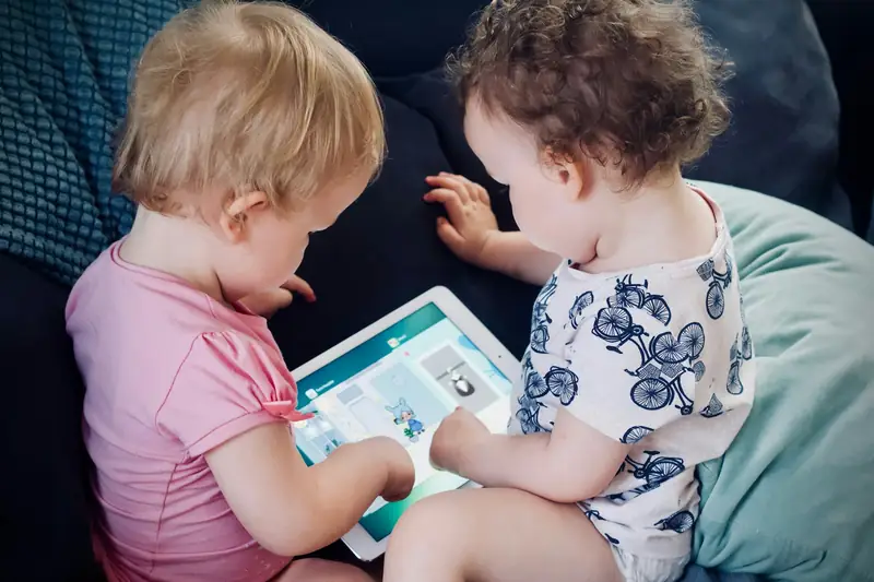 Crianças usando tablet no sofá