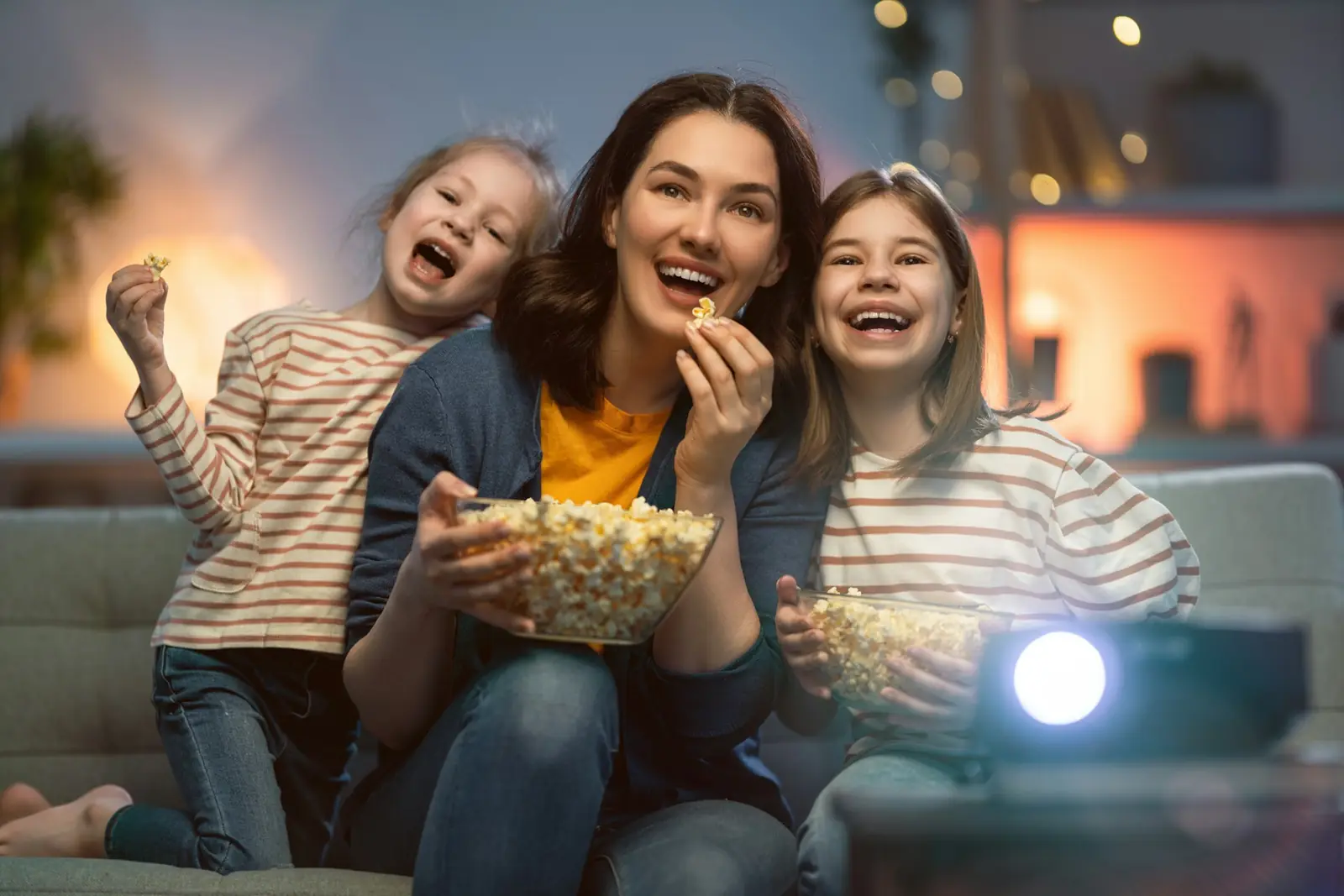 Mãe e filhos assistindo filme com pipoca